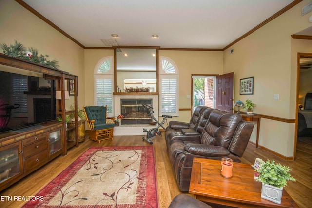 living room with a brick fireplace, light wood-type flooring, and crown molding