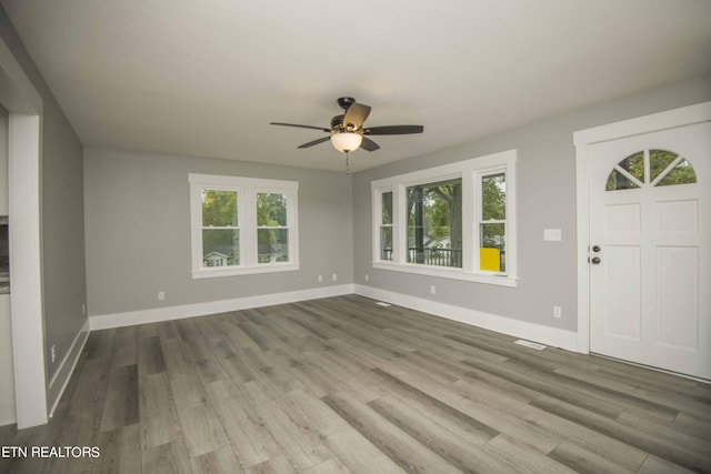 entryway featuring baseboards, a ceiling fan, and wood finished floors