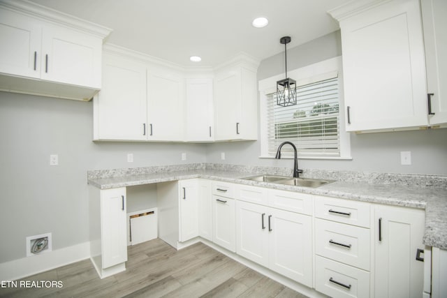 kitchen with white cabinets, recessed lighting, a sink, light wood-style floors, and decorative light fixtures