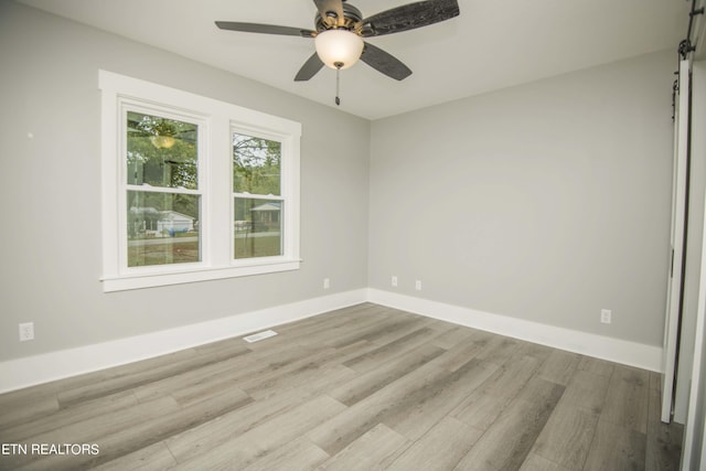 spare room featuring baseboards, a ceiling fan, and wood finished floors