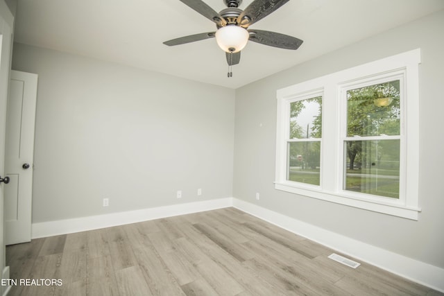 empty room featuring baseboards, a ceiling fan, wood finished floors, and visible vents