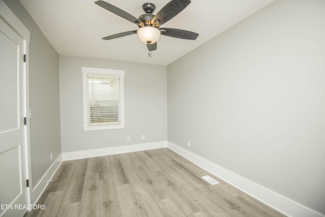 spare room with light wood finished floors, baseboards, ceiling fan, and visible vents