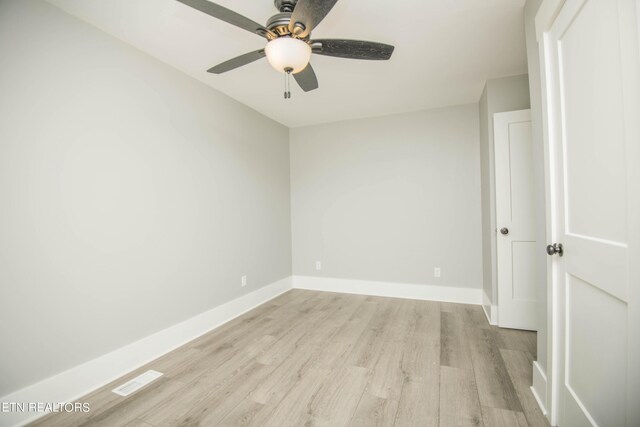 empty room featuring ceiling fan, baseboards, light wood-style floors, and visible vents