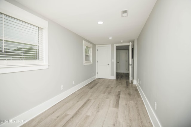 hall featuring baseboards, visible vents, recessed lighting, and light wood-style floors