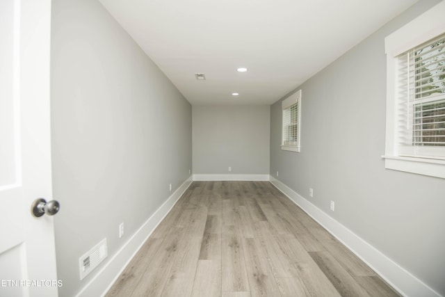 empty room featuring recessed lighting, visible vents, light wood finished floors, and baseboards