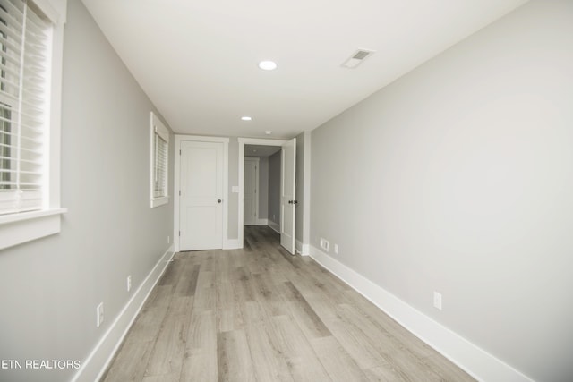 hall with recessed lighting, light wood-style floors, visible vents, and baseboards