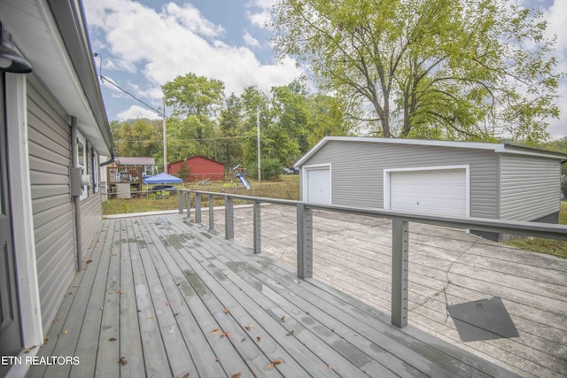wooden deck with an outdoor structure and a garage