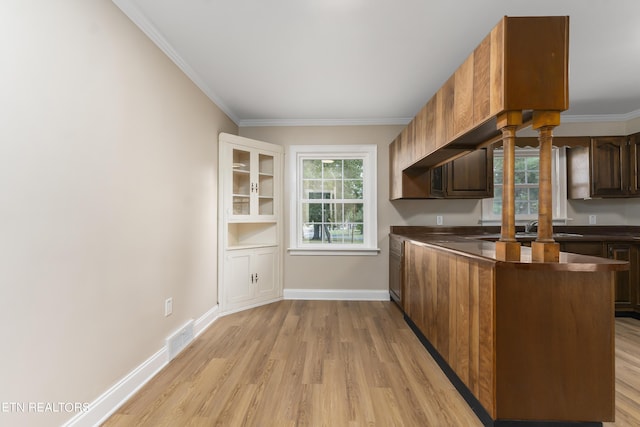 kitchen with kitchen peninsula, light wood-type flooring, and ornamental molding