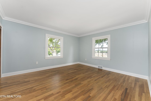 spare room featuring wood-type flooring and crown molding