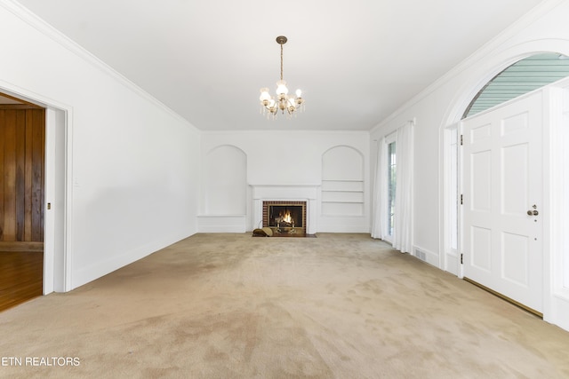 unfurnished living room featuring crown molding, a fireplace, light colored carpet, and a notable chandelier