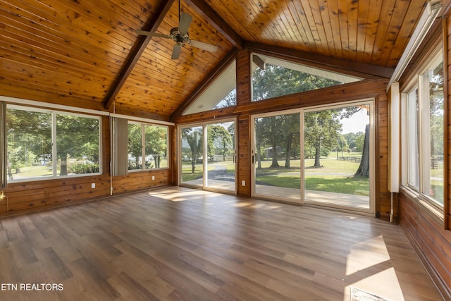 unfurnished sunroom with lofted ceiling with beams, ceiling fan, plenty of natural light, and wooden ceiling