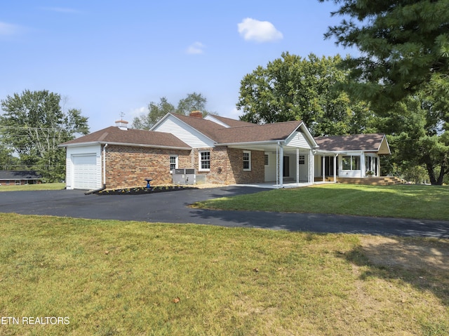 single story home with a porch, a garage, and a front lawn