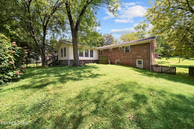 rear view of house featuring a yard