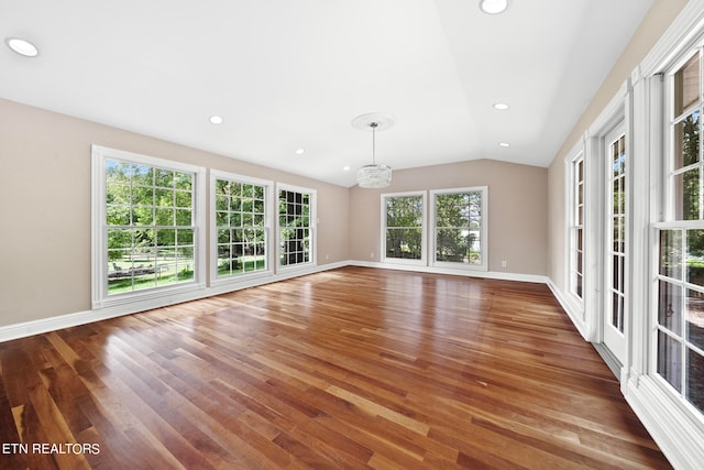 unfurnished living room with wood-type flooring, vaulted ceiling, and an inviting chandelier