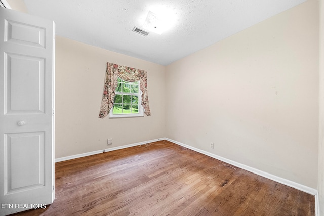 empty room featuring hardwood / wood-style floors and a textured ceiling