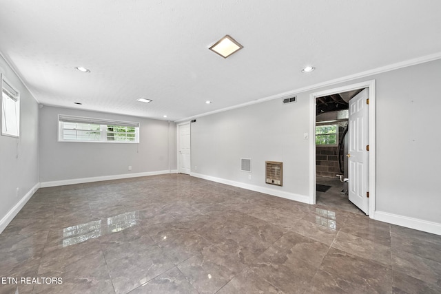 spare room with heating unit, a textured ceiling, and ornamental molding