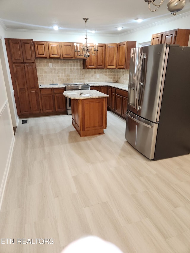 kitchen with backsplash, a kitchen island, hanging light fixtures, and appliances with stainless steel finishes