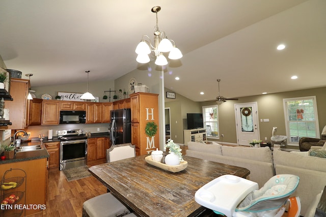 dining room featuring ceiling fan with notable chandelier, lofted ceiling, sink, and dark hardwood / wood-style flooring