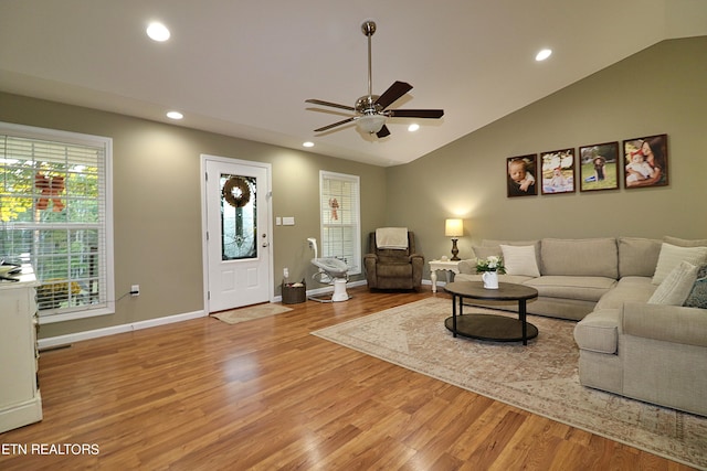 living room with vaulted ceiling, ceiling fan, and light hardwood / wood-style flooring