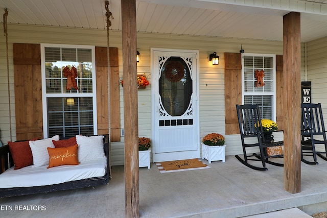 view of exterior entry featuring covered porch