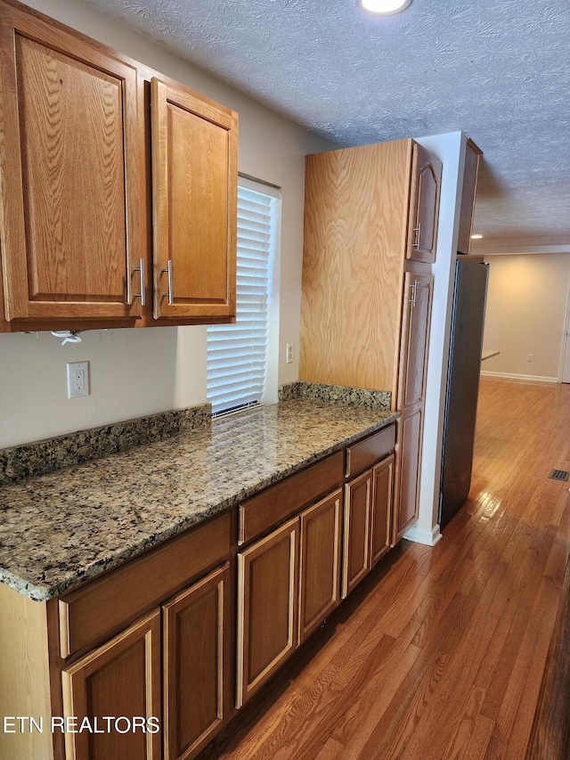 5725 Academy Dr, Morristown, TN 37814 - kitchen with a textured ceiling, stone counters, dark wood-type flooring, and stainless steel refrigerator