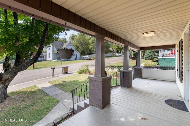 deck with a yard and covered porch