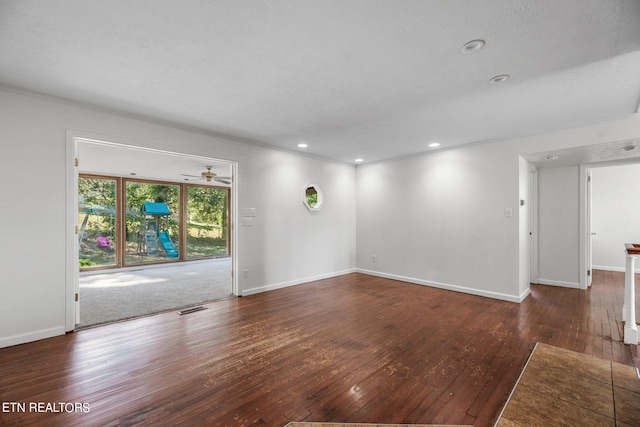 empty room with ceiling fan and dark hardwood / wood-style flooring