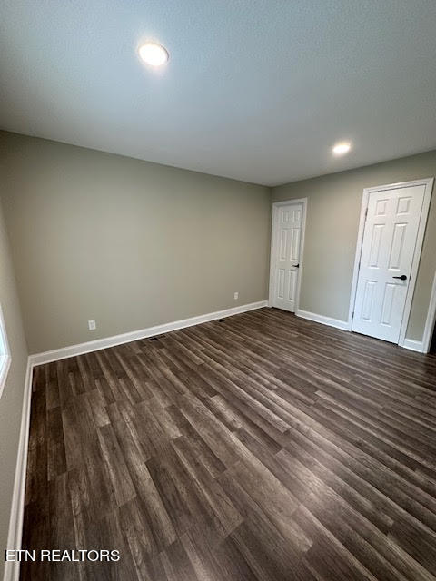 unfurnished bedroom featuring dark wood-type flooring