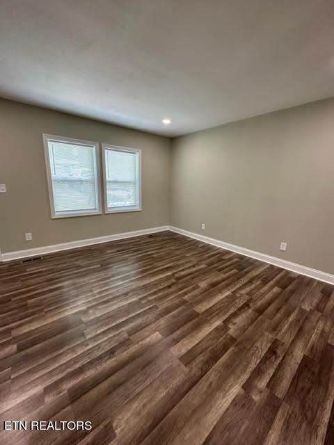 spare room with dark hardwood / wood-style floors