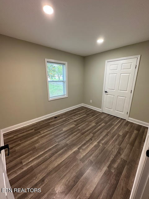 unfurnished bedroom with a closet and dark wood-type flooring