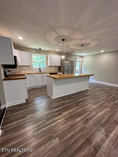 kitchen with a kitchen island, dark hardwood / wood-style flooring, and white cabinets