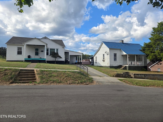 view of front of property featuring a garage, a front lawn, and a porch