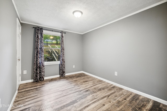 unfurnished room with a textured ceiling, ornamental molding, and hardwood / wood-style flooring