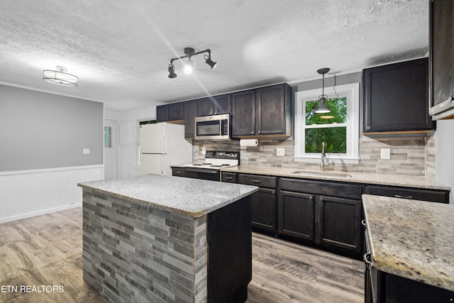 kitchen featuring light hardwood / wood-style flooring, hanging light fixtures, white appliances, and a kitchen island