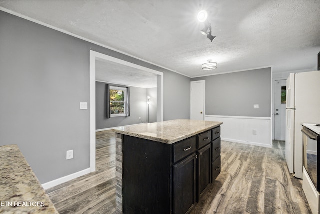 kitchen featuring white refrigerator, a textured ceiling, a center island, and hardwood / wood-style flooring