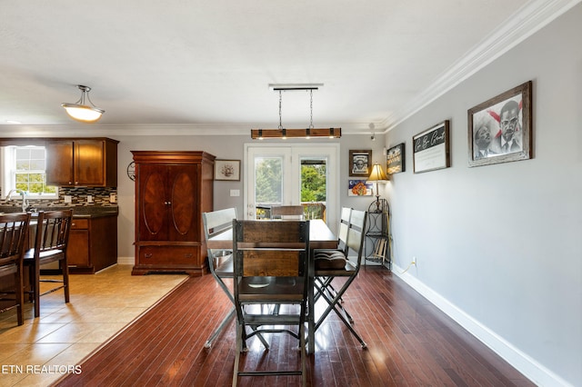 dining area with wood-type flooring, plenty of natural light, and crown molding