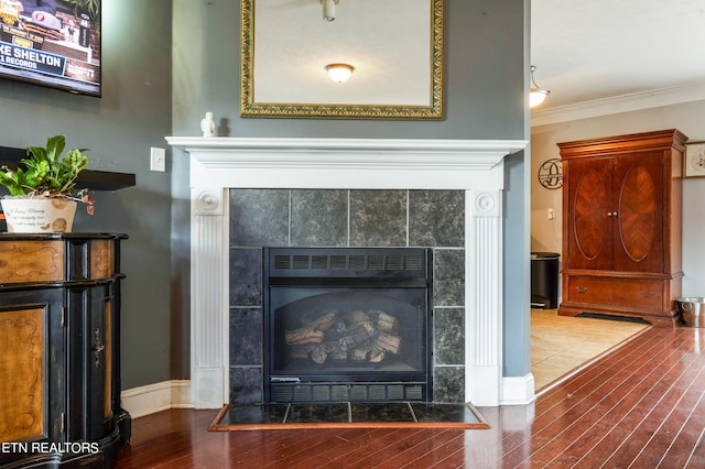 room details featuring a tile fireplace, hardwood / wood-style floors, and crown molding