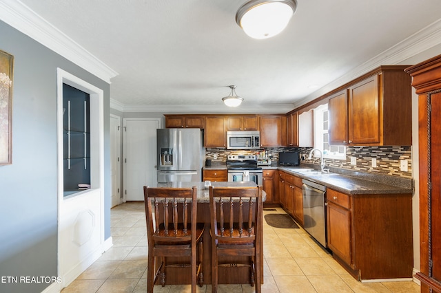 kitchen with light tile patterned flooring, sink, appliances with stainless steel finishes, a center island, and decorative backsplash