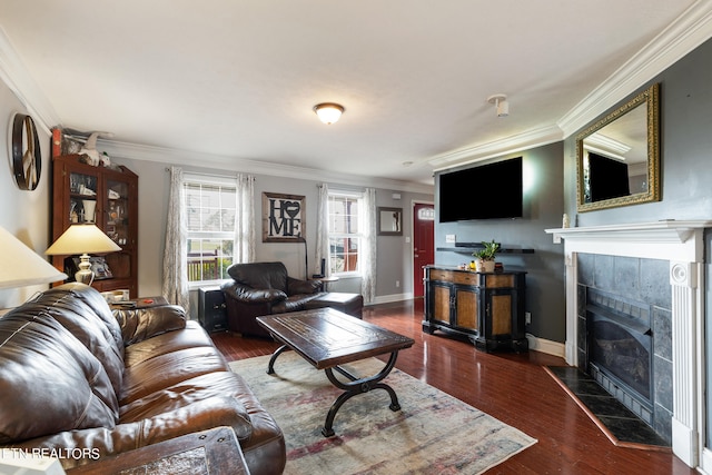 living room featuring a tiled fireplace, dark hardwood / wood-style flooring, and crown molding