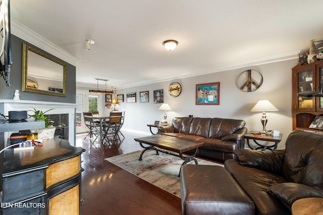 living room featuring ornamental molding, dark hardwood / wood-style flooring, and a tile fireplace