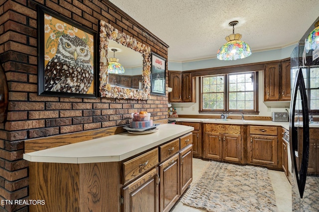 kitchen with a textured ceiling, brick wall, crown molding, and sink