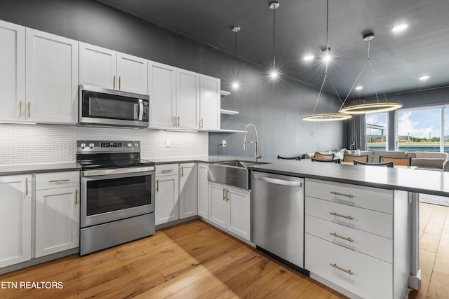 kitchen featuring pendant lighting, white cabinetry, appliances with stainless steel finishes, and sink