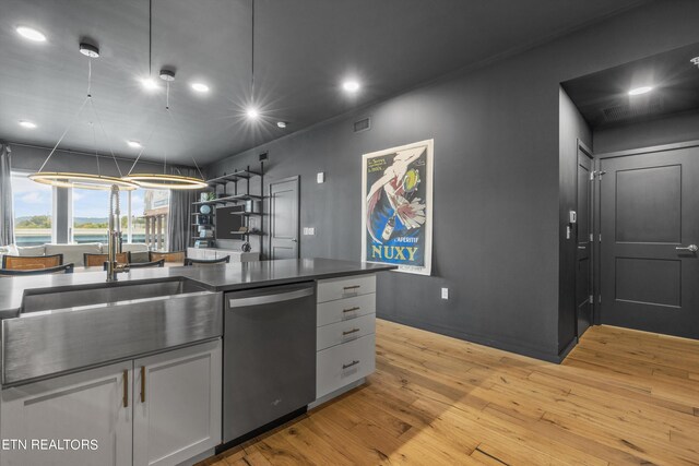 kitchen with stainless steel dishwasher, sink, light hardwood / wood-style flooring, and white cabinets