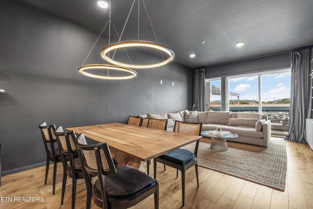 dining space featuring an inviting chandelier and light hardwood / wood-style flooring