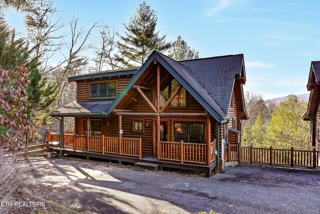 log-style house featuring covered porch