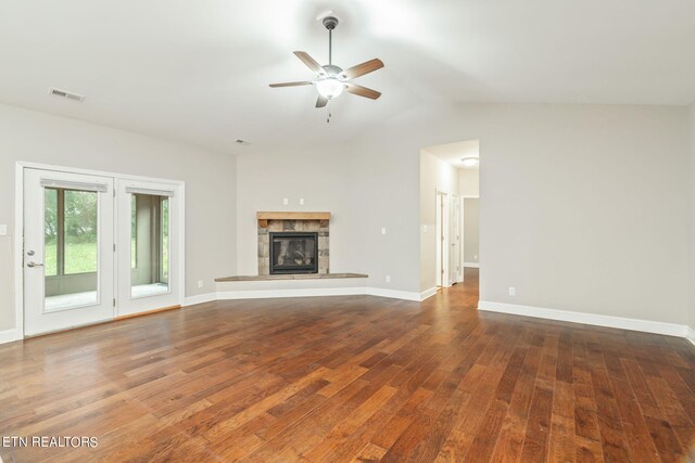 unfurnished living room with a tile fireplace, ceiling fan, dark wood-type flooring, and lofted ceiling