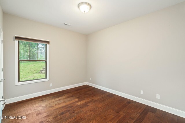 empty room with dark wood-type flooring