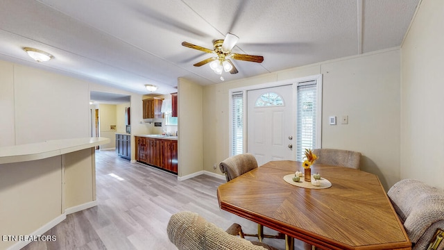 dining area featuring a textured ceiling, ceiling fan, and light hardwood / wood-style flooring