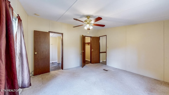 unfurnished bedroom with ceiling fan and dark carpet