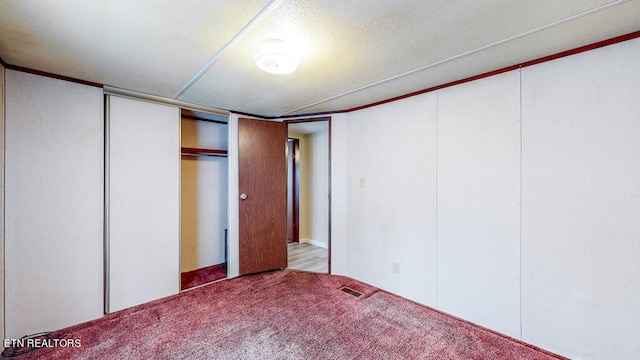 unfurnished bedroom with light carpet and a textured ceiling